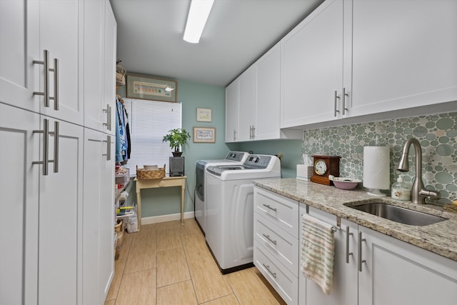 laundry room featuring sink, cabinets, and washing machine and clothes dryer