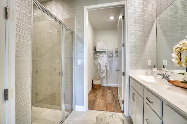 bathroom with tile patterned flooring, vanity, and a shower with door