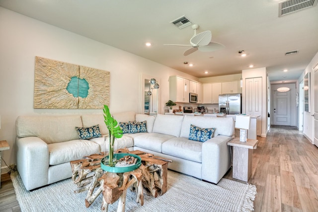 living room with ceiling fan and light wood-type flooring