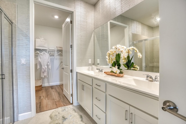 bathroom featuring hardwood / wood-style floors, vanity, and a shower with door