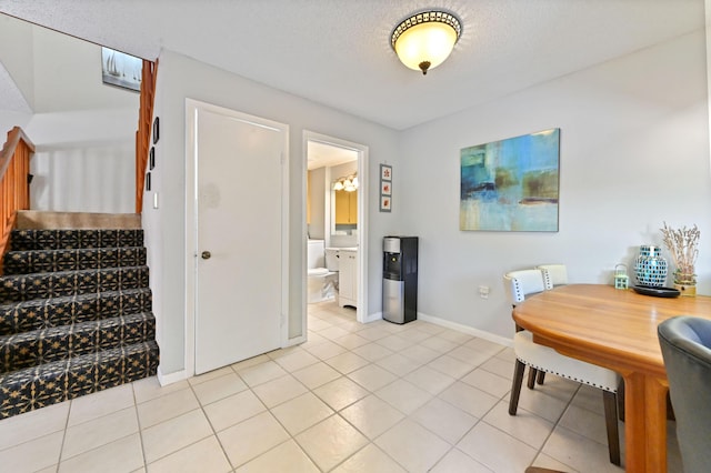 tiled dining room with a textured ceiling