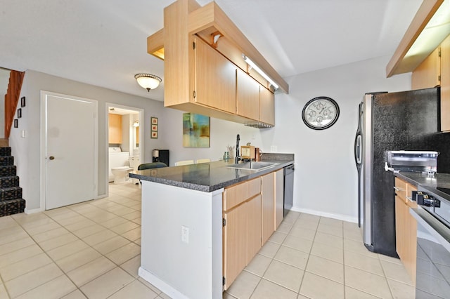 kitchen with kitchen peninsula, sink, light tile patterned floors, and appliances with stainless steel finishes