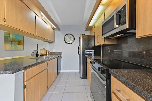 kitchen with sink, kitchen peninsula, decorative backsplash, light tile patterned floors, and appliances with stainless steel finishes