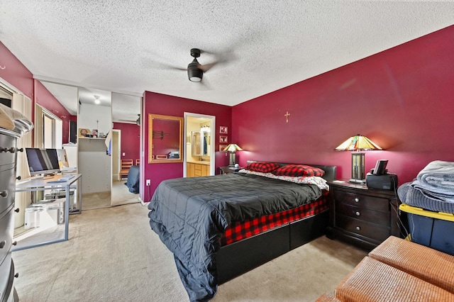 carpeted bedroom featuring ensuite bath, ceiling fan, a closet, and a textured ceiling