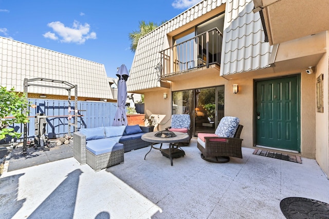 view of patio with an outdoor living space with a fire pit