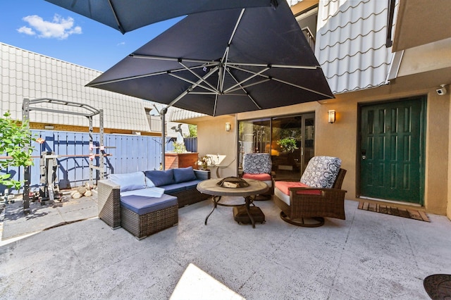 view of patio with an outdoor living space with a fire pit