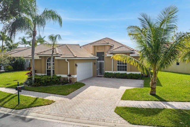 mediterranean / spanish house featuring a front yard and a garage