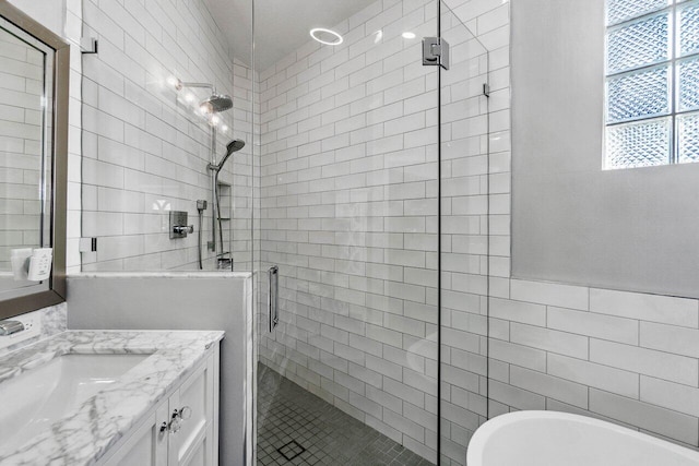 bathroom with vanity, plus walk in shower, and tile walls