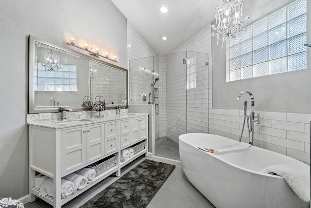 bathroom featuring tile walls, vanity, tile patterned floors, and independent shower and bath