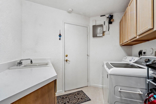 laundry area with cabinets, washer and clothes dryer, and sink