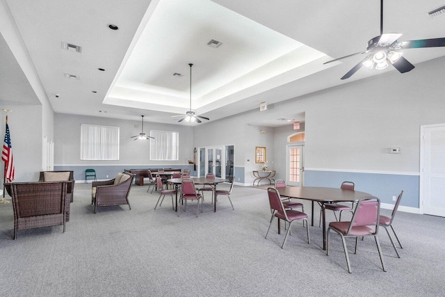 dining room featuring a tray ceiling and carpet floors