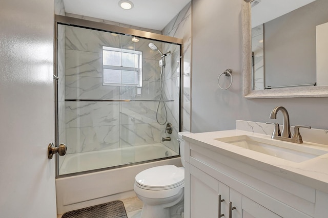 full bathroom with vanity, toilet, and combined bath / shower with glass door