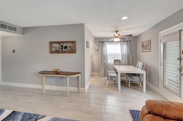 dining room featuring a textured ceiling and ceiling fan