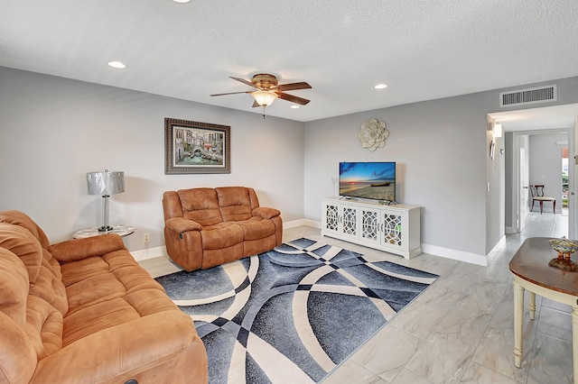 living room featuring a textured ceiling and ceiling fan