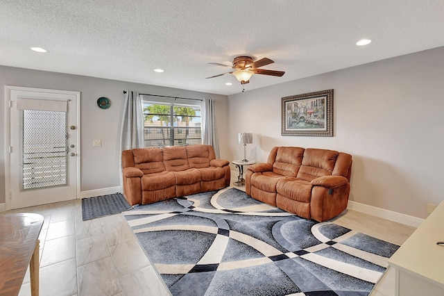 living room featuring a textured ceiling and ceiling fan