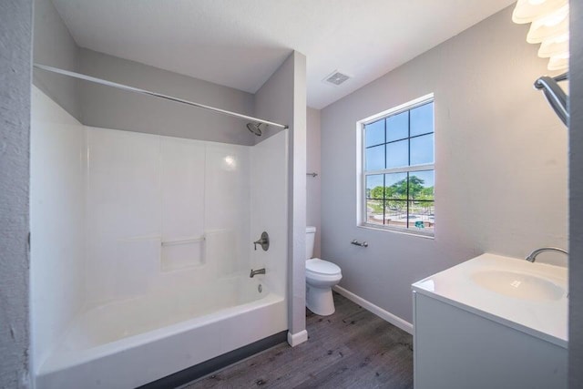 full bathroom with vanity, hardwood / wood-style flooring,  shower combination, and toilet