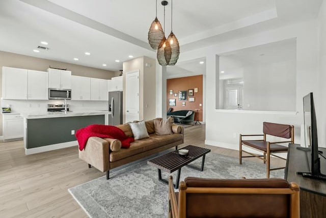 living room featuring light wood-type flooring and sink