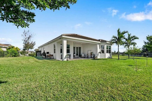 back of house with a patio and a lawn