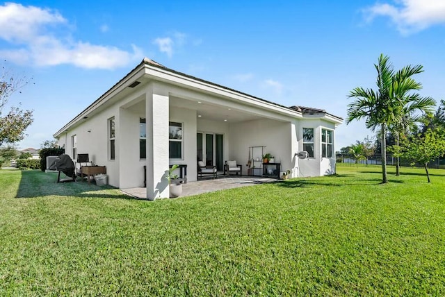 back of property featuring a yard and a patio area