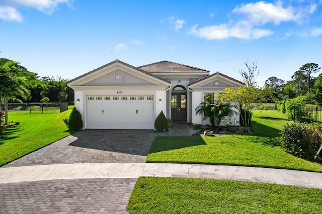 view of front facade featuring french doors, a garage, and a front lawn