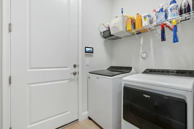 laundry area featuring independent washer and dryer and light hardwood / wood-style flooring