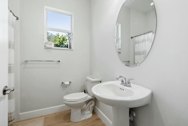 bathroom featuring walk in shower, wood-type flooring, and toilet