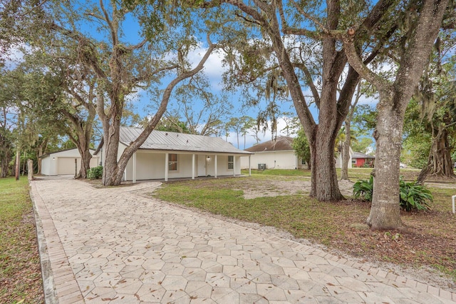 ranch-style house featuring a front yard, an outdoor structure, and a garage