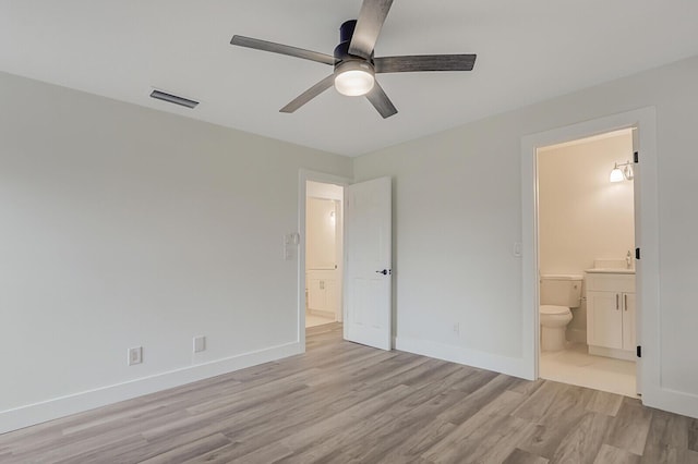 unfurnished bedroom with connected bathroom, ceiling fan, sink, and light wood-type flooring