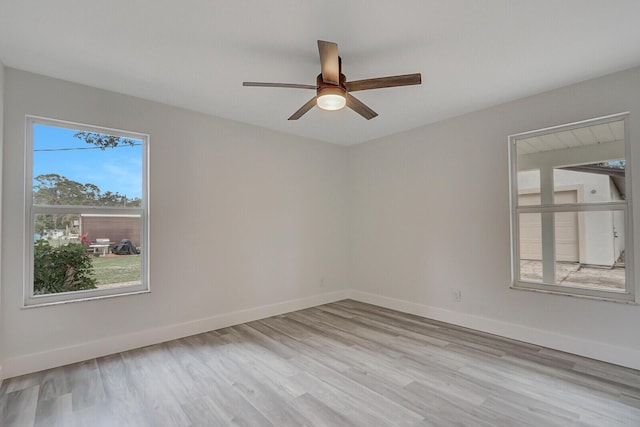 empty room with light hardwood / wood-style floors, a wealth of natural light, and ceiling fan