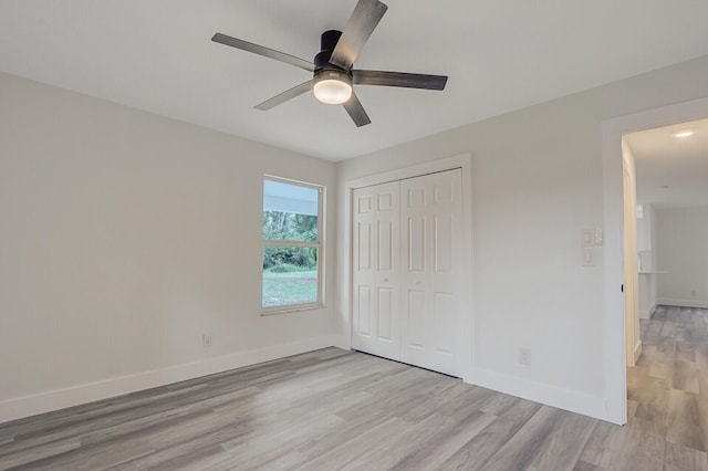 unfurnished bedroom with ceiling fan, light hardwood / wood-style floors, and a closet