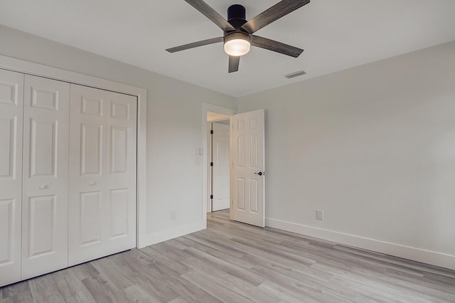 unfurnished bedroom with ceiling fan, a closet, and light hardwood / wood-style floors