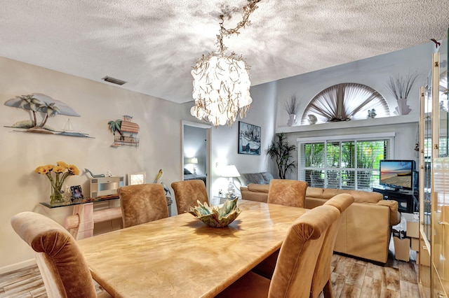 dining area featuring a chandelier and a textured ceiling