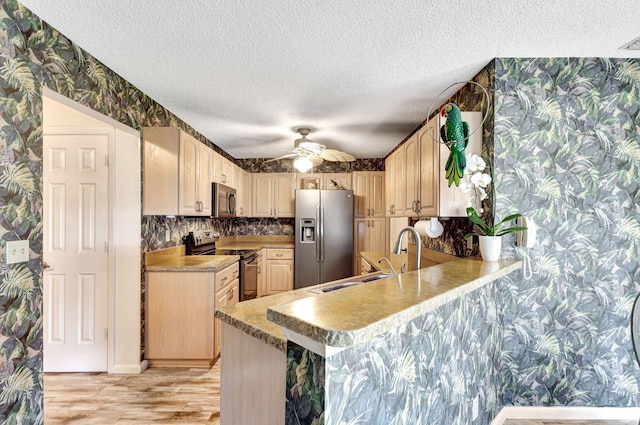 kitchen featuring kitchen peninsula, appliances with stainless steel finishes, a textured ceiling, ceiling fan, and sink