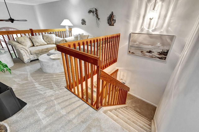 stairs with ceiling fan and carpet