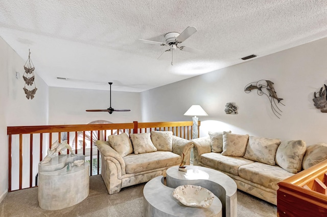 carpeted living room with ceiling fan and a textured ceiling