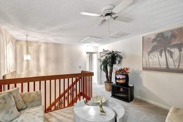 corridor featuring light colored carpet and a textured ceiling