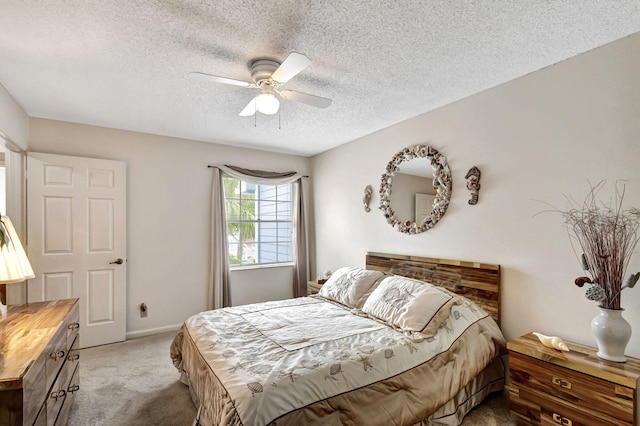 carpeted bedroom featuring a textured ceiling and ceiling fan