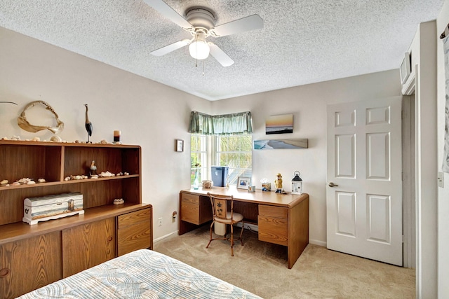 carpeted bedroom with ceiling fan and a textured ceiling