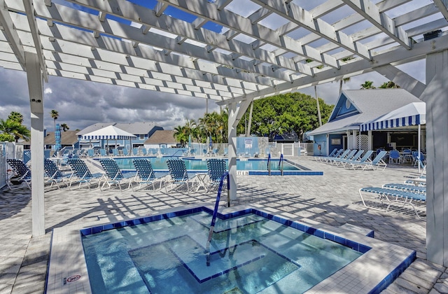 view of swimming pool featuring a community hot tub, a pergola, and a patio