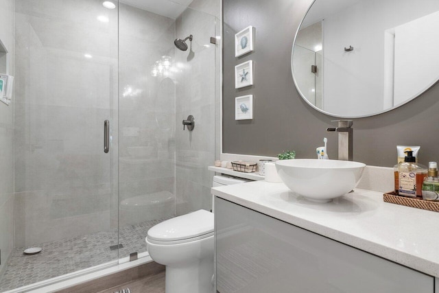 bathroom featuring wood-type flooring, vanity, toilet, and walk in shower