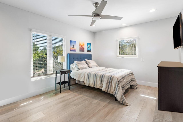 bedroom featuring multiple windows, light wood-type flooring, and ceiling fan