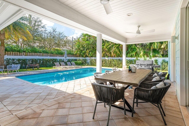 view of swimming pool with ceiling fan, a patio area, and grilling area