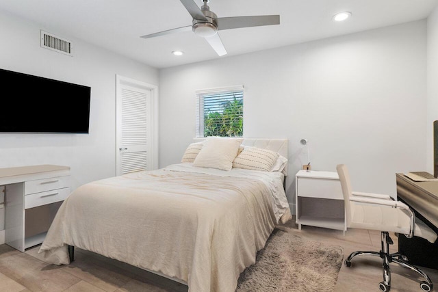 bedroom with ceiling fan, a closet, and light hardwood / wood-style floors