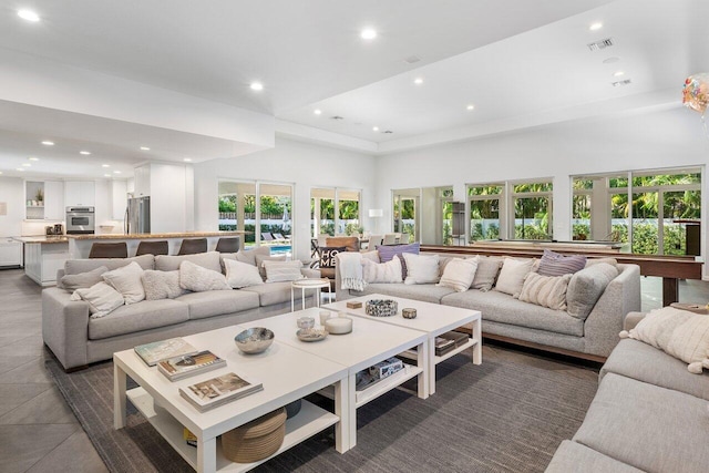 living room featuring a towering ceiling and a wealth of natural light