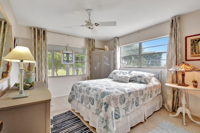 bedroom with ceiling fan and light carpet