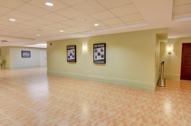 basement with a drop ceiling and light tile patterned flooring