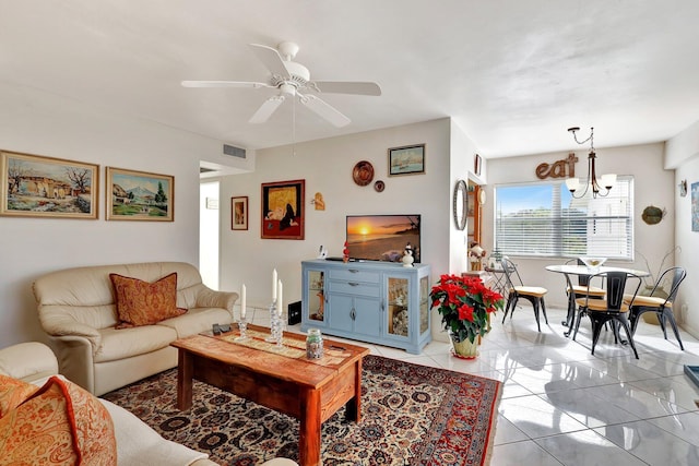 living room with ceiling fan with notable chandelier and light tile patterned floors