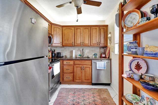 kitchen with backsplash, sink, ceiling fan, light tile patterned floors, and stainless steel appliances