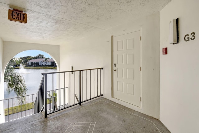 entrance to property with a water view and a balcony