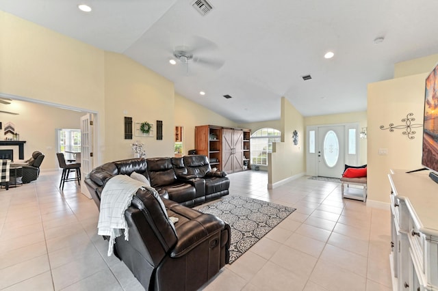 living room featuring light tile patterned floors, plenty of natural light, ceiling fan, and lofted ceiling